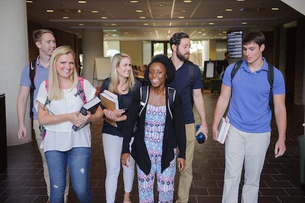 A group of law students walk through the law school lobby.